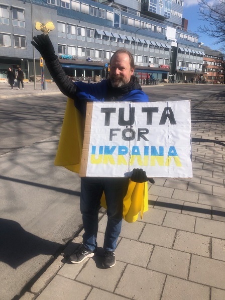 Demonstrant uppmanar bilister att tuta vid ryska ambassaden, mittemot Expressen-huset